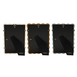 Rear view of three Baby Wiggle photo frames in cream, ochre and blue with wavy edges, showing black backing boards and fold-out stands on a white background.