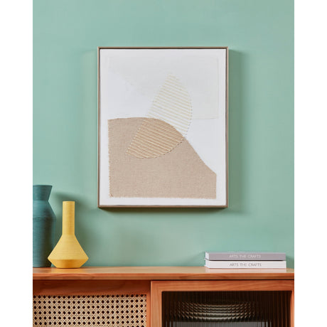 Mentakab framed abstract wall art in cream, beige and brown with textured leaf shapes, shown above a wooden sideboard against a teal wall.