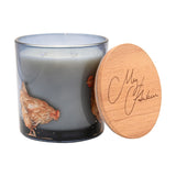 Chickens Honey & Oats 2 Wick Scented Candle in a round smoky grey glass jar painted with russet hens, two wicks visible, with a wooden lid resting beside it on a white background.