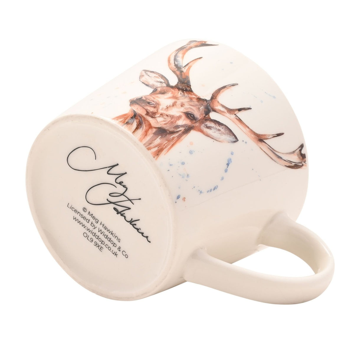 Off-white ceramic cup shown on its side, featuring a watercolour stag's head with antlers in russet tones, paint splashes, and a signature on the base, set against a plain white background.