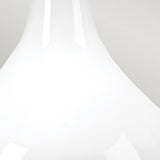 Close-up of the Milo 1 Light Table Lamp featuring a white, glossy ceramic base with a smooth, curved shape reminiscent of a neck on a vase. The background is light gray, which complements the shiny ceramic texture and highlights subtle aged brass accents.