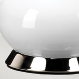 A close-up of the Milo 1 Light Table Lamp showcases its sleek, modern design, featuring an eye-catching reflective polished nickel base. The lamp's smooth white globe casts subtle light reflections, beautifully contrasting with its optional orange shade for a minimalist aesthetic.