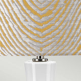 Close-up of this decorative Milo 1 Light Table Lamp - Polished Nickel/Yellow features a textured yellow drum shade adorned with a silver and gold geometric pattern. Its white base is accented with polished nickel, offering an elegant touch to any room.