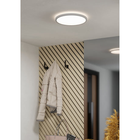 Minerario LED Flush Ceiling Light 30cm in white, round opal shade, shown illuminated on a hallway ceiling above wall hooks with a coat hanging on panelled wood wall.