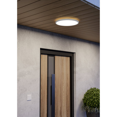 Minerario LED flush ceiling light in white, 39cm round disc with opal diffuser, shown illuminated on a wooden porch ceiling above a front door.