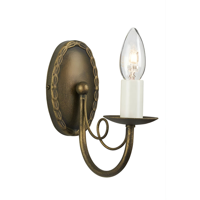 The Minster 1 Light Wall Light - Black/Gold Patina is a wall-mounted fixture with an antique-style design, featuring a candle-like bulb set in a decorative arm and base with a bronze finish. Its intricate detailing on the round backplate evokes a vintage aesthetic, providing soft ambient lighting to enhance any room's charm.