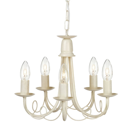 The Minster 5 Light Chandelier in Ivory and Gold Patina displays a vintage charm with its five candle-shaped light bulbs, elegant curved arms, and a matching chain that enhances its appeal against a plain white background.