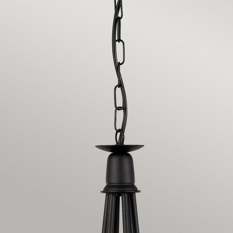 A close-up of the Minster 6 Light Chandelier in black showcases a visible chain link, elegantly suspended against a plain light gray background.