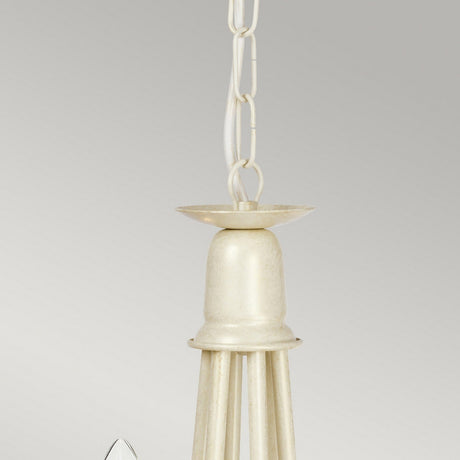 A close-up of the Minster 6 Light Chandelier - Ivory/Gold Patina with a chain showcases its smooth, cone-shaped top that extends into a geometric design. Its elegant finish stands out against the plain gray background.