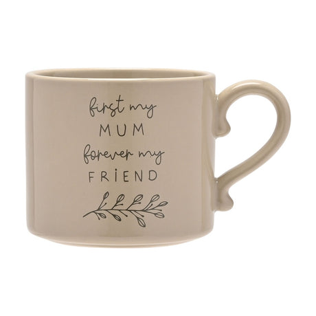 Stoneware mug in soft brown glaze with curved handle, featuring "first my MUM forever my FRIEND" script text and a leaf sprig design, shown on a plain white background.