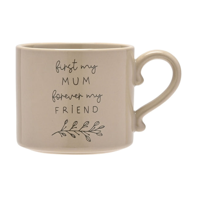 Stoneware mug in soft brown glaze with curved handle, featuring "first my MUM forever my FRIEND" script text and a leaf sprig design, shown on a plain white background.