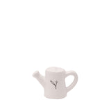 Mini ceramic watering can ornament in off-white, with a rounded body, short angled spout, curved loop handle, and a sprig motif on the side, shown on a plain white background.