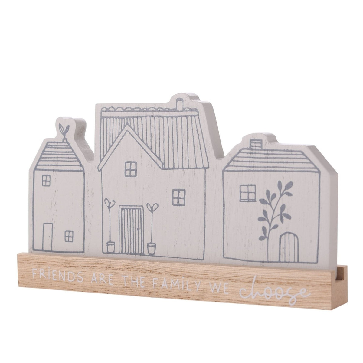 Grey wooden mantel plaque shaped like three houses with line-drawn windows, doors and chimneys, set on a natural wood base reading "Friends Are The Family We Choose," against a plain white background.