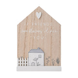 House-shaped wood plaque in natural and white with a heart detail, "If friends were flowers I'd pick you" text, and a white cottage with picket fence and flowers on a white base.
