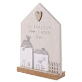Grey house-shaped wooden plaque with a cut-out heart, white polka dots, raised cottage shapes, and the text I'm exactly where I need to be, on a plain white background.