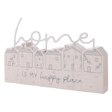 White wooden mantel plaque with grey line-drawn houses, topped by a looping "home" script, reading "home IS MY happy place" on a plain background.