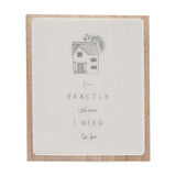 Layered wooden plaque with a white glazed panel on natural wood backing, featuring a grey line-drawn house and the handwritten message "I'm exactly where I need to be".