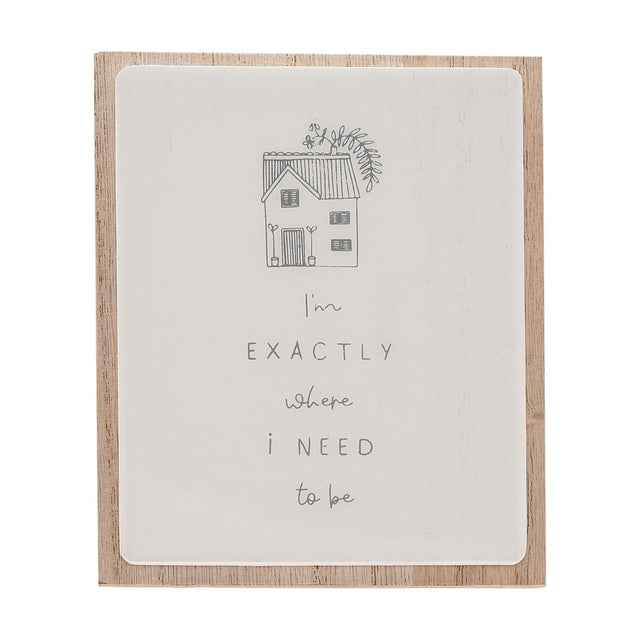 Layered wooden plaque with a white glazed panel on natural wood backing, featuring a grey line-drawn house and the handwritten message "I'm exactly where I need to be".