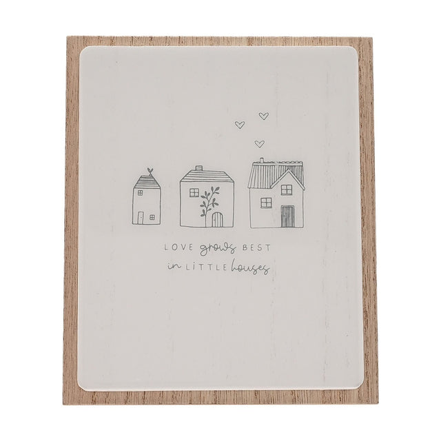 Wooden plaque with easel stand, featuring a white panel on natural wood backing, hand-drawn grey houses, hearts, and "Love grows best in little houses" lettering.