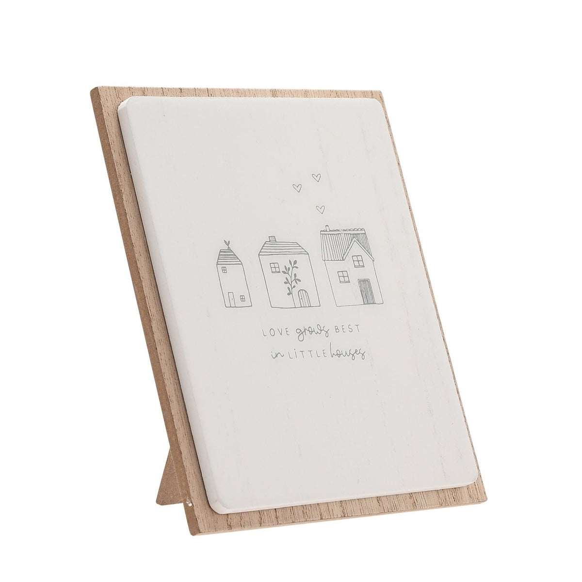 Grey wooden plaque with easel stand featuring three line-drawn houses, hearts, and the text Love grows best in little houses on a white panel with natural wood border.
