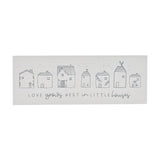 White rectangular wooden mantel plaque with seven line-drawn houses and grey text reading "Love grows best in little houses" on a plain background.