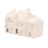 White ceramic tea light holder shaped as three terraced houses with ribbed roofs, chimneys, cut-out windows and doors, middle house reading "I'm EXACTLY where I NEED to be".