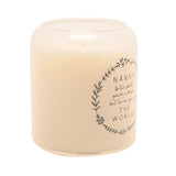 Round cream scented candle in a glass jar, printed with a grey leafy wreath and "Nanna...THE WORLD" sentiment, shown on a plain white background.