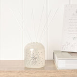 Thank You Heart Print Reed Diffuser 200ml in cream glass with grey heart dots and white reeds, displayed on a wooden shelf beside books.
