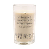 Tall scented candle in a clear glass jar with cream wax, printed with a heart, friendship quote, and a row of line-drawn houses, shown on a plain white background.