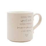 Cream ceramic mug with curved handle, featuring grey text "Good times spent with good friends become precious memories" and a small heart outline, on a plain white background.