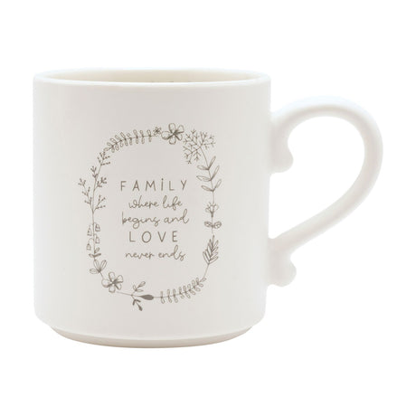 Cream ceramic mug with curved handle, featuring a grey floral wreath design and "FAMILY where life begins and LOVE never ends" text, shown on a plain white background.