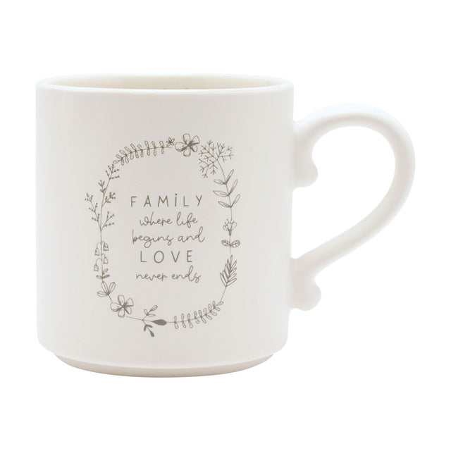 Cream ceramic mug with curved handle, featuring a grey floral wreath design and "FAMILY where life begins and LOVE never ends" text, shown on a plain white background.
