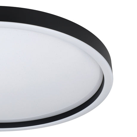 Close-up of the Montemorelos round LED flush ceiling light, showing its black aluminium rim and white crystal-effect plastic diffuser, on a plain white background.