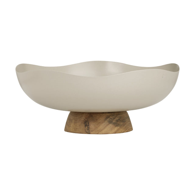 Monywa decorative bowl in cream-coloured metal with a wavy, organic rim, raised on a short wooden pedestal foot, shown on a plain white background.