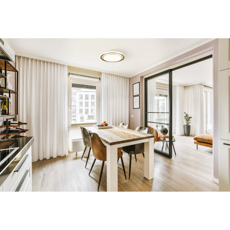 Moschetta LED Flush Ceiling Light 49cm in Gold with stepped rings, fitted above a wooden dining table in a bright kitchen-diner setting.