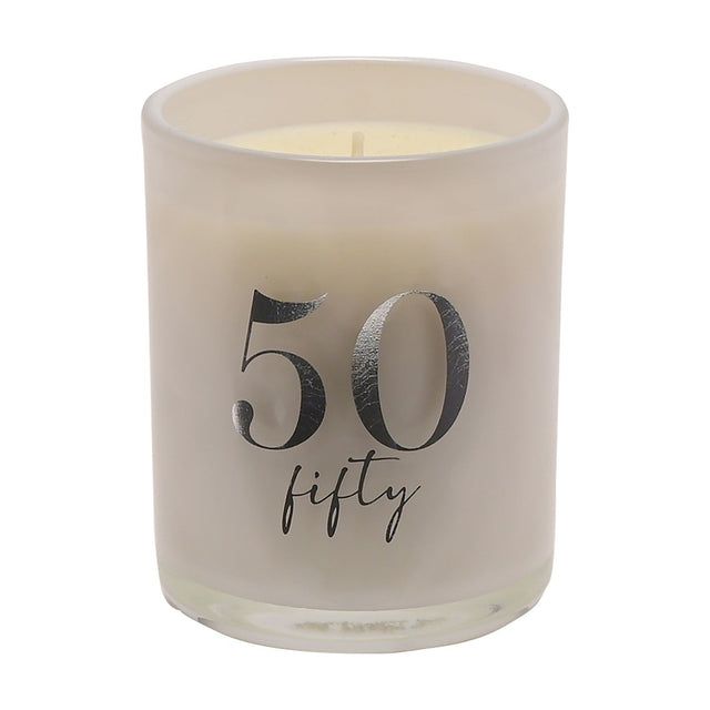 White cylindrical glass candle holder with pearly sheen, printed with a bold silver "50" and "fifty" script, cream wax candle inside, on a plain white background.