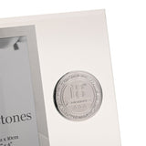 Close-up of clear glass photo frame with bevelled edge, showing round silver metal 18th Birthday badge with star details beside the rectangular picture window.