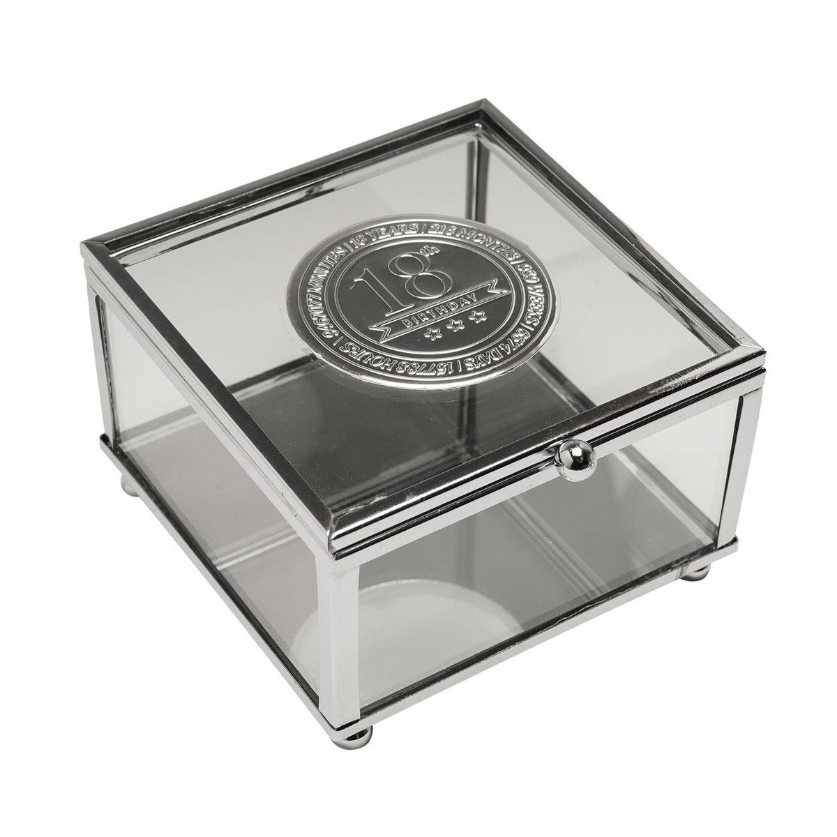 Square glass trinket box with slim silver metal frame and a round silver metal badge on the lid reading "18th Birthday," shown on a white background.