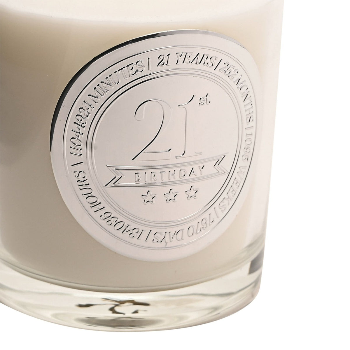 Close-up of the 21st Birthday Sandalwood Scented Candle in cream wax with a round silver medallion reading "21st Birthday" and three stars, bordered by a years-to-days countdown.