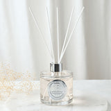 18th Birthday Sandalwood Reed Diffuser 200ml in a round clear glass bottle with silver collar and white reeds, with a silver number 18 seal, set on a marble surface.