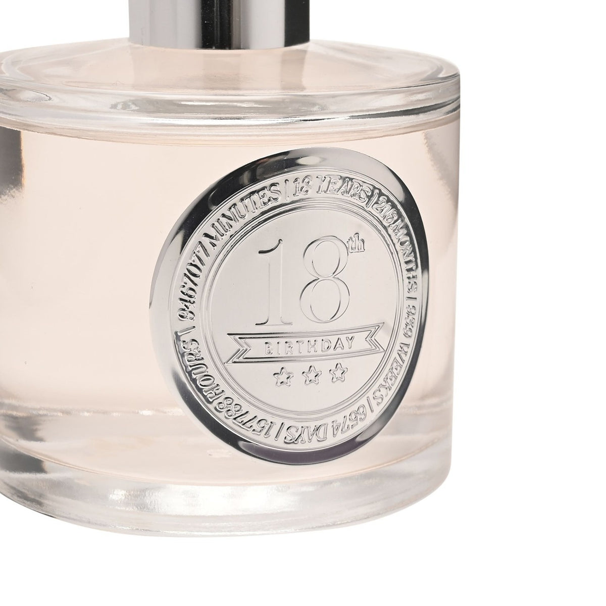 Close-up of the 18th Birthday Sandalwood Reed Diffuser's round clear glass bottle, showing a silver collar embossed with "18th Birthday" and pale blush liquid inside.