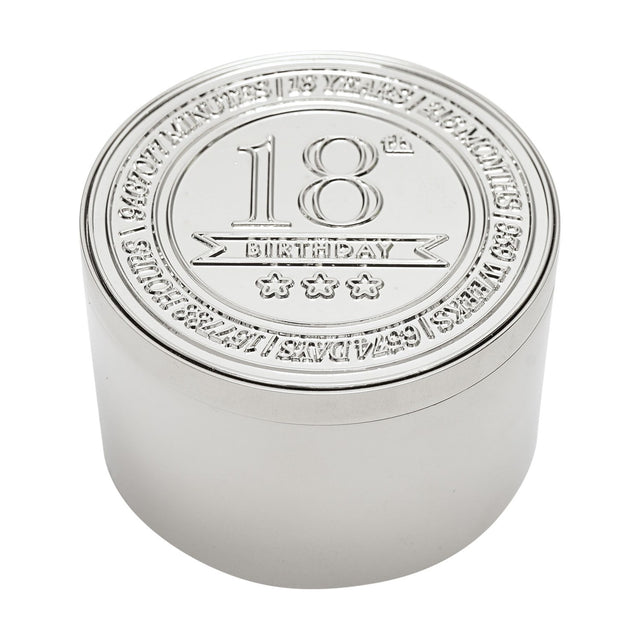 Round silver metal trinket box with embossed lid reading "18th Birthday" above three stars, encircled by engraved text, on a plain white background.