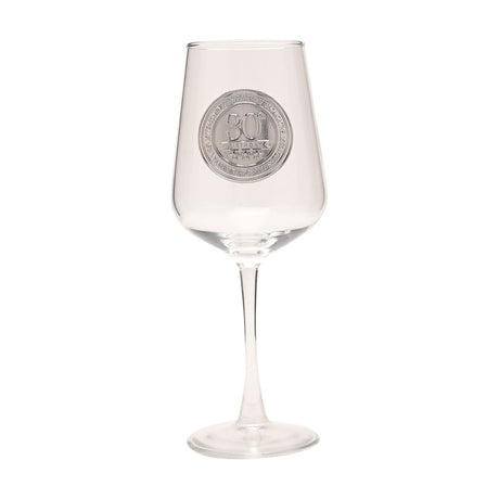 Clear stemmed wine glass with a round silver "30" badge on the bowl, tapered rim, slender stem, and wide flat foot, shown on a plain white background.