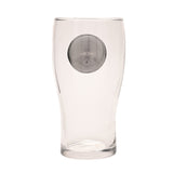Clear glass pint beer glass with a curved shape and raised silver circular badge on the front, shown on a plain white background.