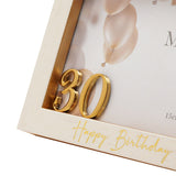 Close-up of a white and gold 6x4in photo frame with raised 3D gold "30" numerals in the corner and "Happy Birthday" in gold script along the lower edge.