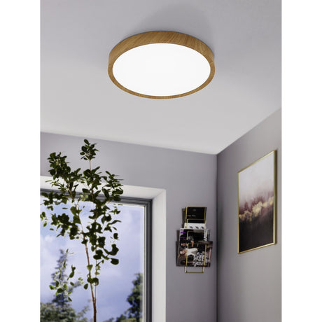 Musurita LED Flush Ceiling Light 44cm, round fixture with natural wood effect rim and white diffuser, shown illuminated on a grey ceiling in a hallway setting.