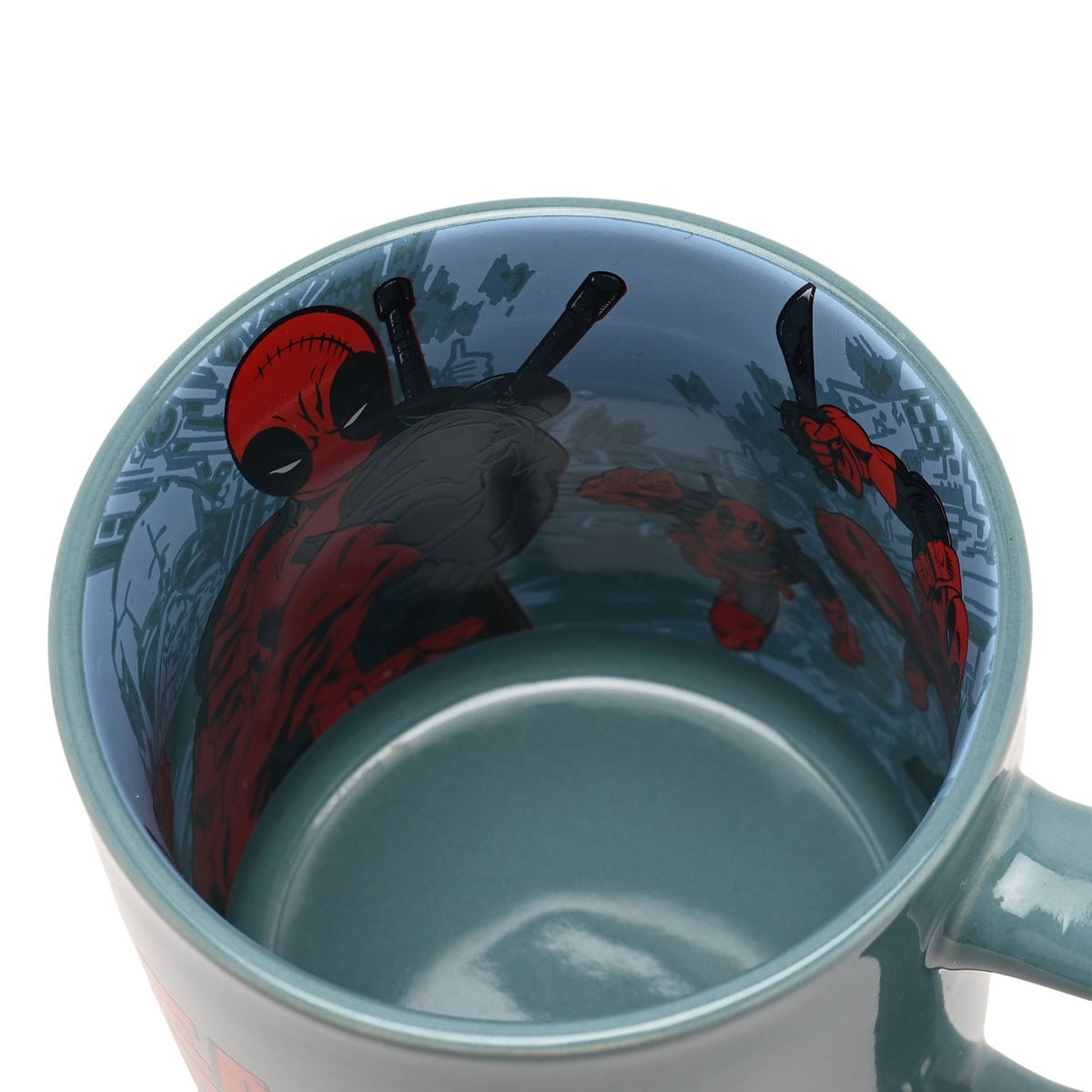 Green porcelain Deadpool mug viewed from above, showing a pale blue interior decal of the character with swords drawn over his shoulders.