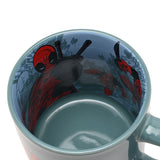 Green porcelain Deadpool mug viewed from above, showing a pale blue interior decal of the character with swords drawn over his shoulders.