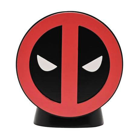 Round resin money box featuring the Deadpool emblem in red and black with white glaring eyes, set on a curved black stand against a plain white background.