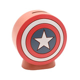 Round resin money box shaped like Captain America's shield, with red and white rings, blue centre and white star, coin slot on top, shown on a plain white background.